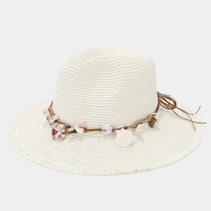 Dettaglio di un cappello di paglia con decorazioni di conchiglie e bordo sfrangiato