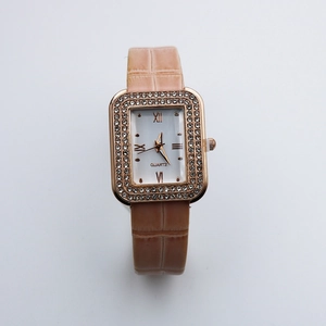 Macro view of rectangular rose gold case with double-row rhinestones and Roman numerals