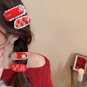 Détail de pinces à cheveux festives rouges avec broderies et ornements de danse du lion