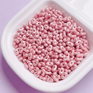 Macro detail of pink pearlescent double-hole oval beads for DIY jewelry making accessories