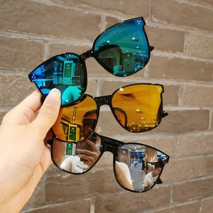 Detailed view of oversized kids sunglasses with reflective blue, orange, and silver lenses