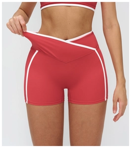 Gros plan sur le short de yoga rouge avec taille croisée en V et liseré blanc contrastant