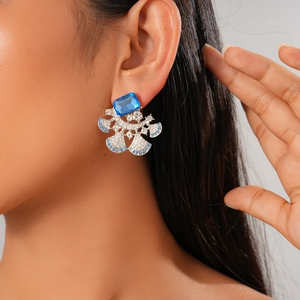 Luxurious fan-shaped earrings with blue square gems and sparkling rhinestones on model