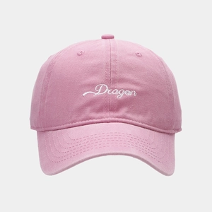 Detail of pink cotton baseball cap featuring white Dragon embroidery and curved brim