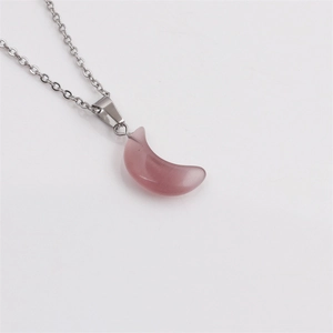 Vue macro d'une chaîne argentée avec un pendentif croissant de lune rose-violet