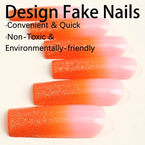 Faux ongles extra longs dégradé orange et rose avec paillettes dorées et pointes plates