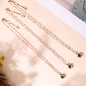 Collier en or rose avec gravure de chiffres romains et pierre en verre vert émeraude