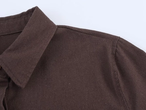 Detail of brown linen shirt showing lapel collar and shoulder stitching texture