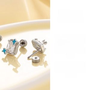 Detailed view of silver star earrings with blue accents and rectangle zircon stones