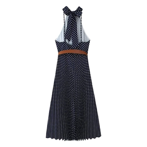 Detail of navy polka dot halter dress with brown belt and pleated midi skirt