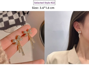 Detailed view of silver needle bow tassel earrings with sparkling white rhinestones