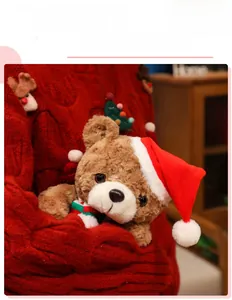 Close-up of plush Christmas teddy bear with striped scarf and red hat in cozy setting