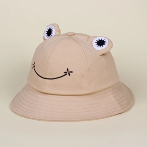 Detailed close-up of cute 3D frog eyes and embroidered smile on beige cotton sun hat