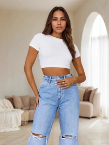 Minimalist white cropped T-shirt paired with light blue distressed high-waisted jeans