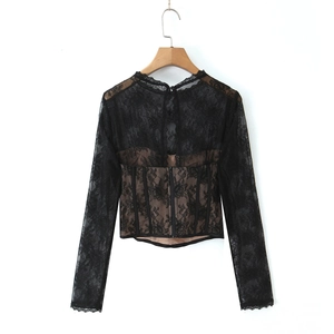 Close-up of black lace patchwork top with corset boning and sheer sleeves