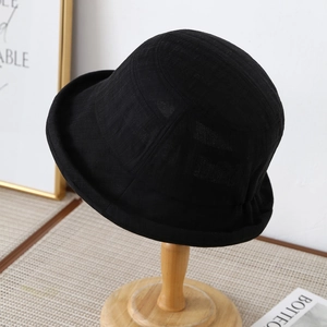 Detail of black textured cotton bucket hat with rolled brim on a wooden stand