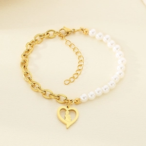 Detail of heart pendant with virgin mary relief on gold chain and pearl bracelet