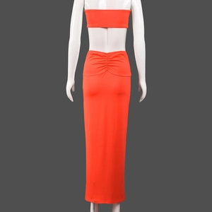 Detail view of bright orange back ruching on the slim fit long skirt and crop top set