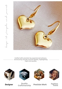 Macro shot of minimalist gold heart-shaped earrings on soft textured background fabric