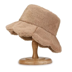 Detail view of khaki faux rabbit fur bucket hat texture on a round wooden base