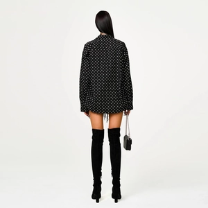 Rear view of black long-sleeve shirt with all-over white cross pattern and loose fit