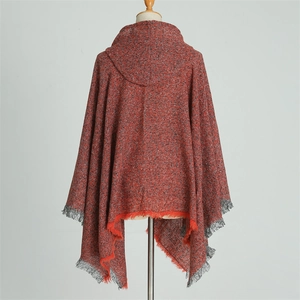Detail of red and grey knitted hooded poncho with tassel trim and textured fabric