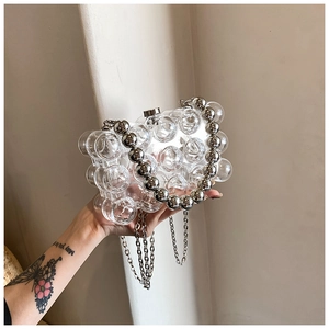 Detail of clear acrylic bubble evening bag with silver metal chain strap and handle