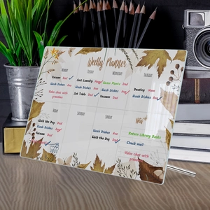 Macro shot of an acrylic weekly planner on a wooden desk with a silver metal stand