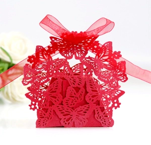 Detailed macro view of laser-cut red butterfly candy box with a silk ribbon bow