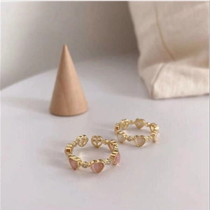 Detail of pink and white cat eye heart rings with gold adjustable open bands