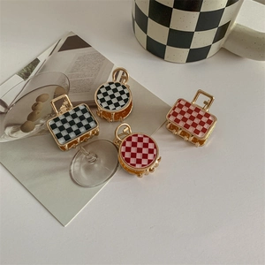 Checkerboard pattern hair claw clips set in black, white, and red on metal base