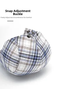 Detail of adjustable metal buckle on plaid newsboy cap with breathable fabric texture