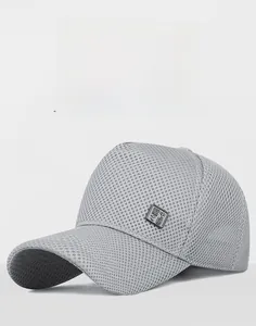 Macro detail of breathable sandwich mesh fabric and metal emblem on light gray baseball cap