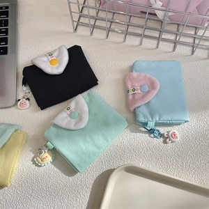 Close-up of cute canvas coin purses with plush flaps and cartoon animal charms in four colors