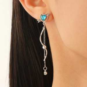 Detail of Cupid heart drop earring with sky blue gemstone, pearl, and zircon on model