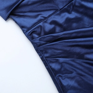 Macro shot of navy blue satin dress fabric with elegant ruching detail and silky texture
