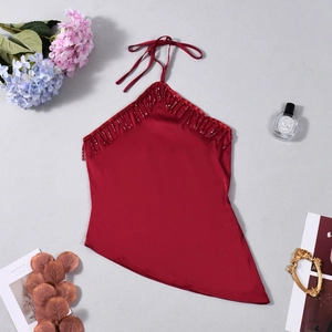 Détail du haut licou en satin bordeaux avec franges perlées et ourlet asymétrique élégant