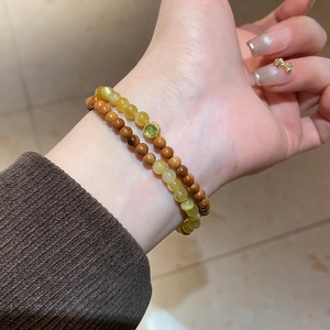 Gros plan d'un bracelet double couche avec perles d'ambre et de bois sur un poignet