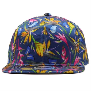 Detail of tropical floral and butterfly print on a navy blue snapback flat brim cap