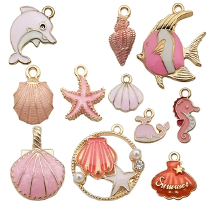 Assorted gold-tone ocean-themed enamel charms including starfish and shells for DIY jewelry