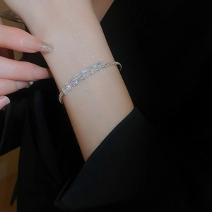 Macro shot of silver-tone chain bracelet with five baguette-cut zircon stones on wrist