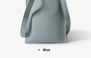 Detail of light blue crossbody bag featuring premium pebble leather texture and stitching