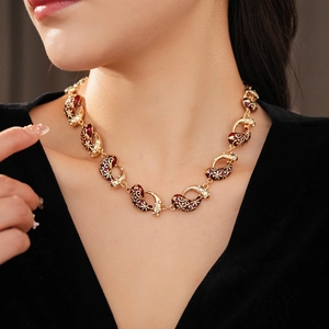 Detail of vintage enamel necklace with reddish-brown elements and small diamonds on a model