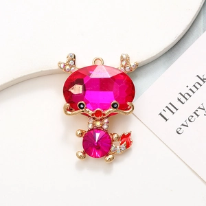 Macro shot of a dragon-shaped gold alloy charm with pink crystals and colorful rhinestones