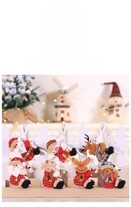 Detail view of plush Christmas ornaments with Santa, snowman, and reindeer on fence