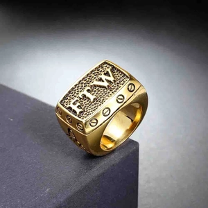 Macro shot of gold square stainless steel ring featuring FTW relief and screw details