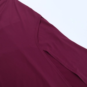 Gros plan sur la fente latérale et la couture double aiguille de la robe bordeaux