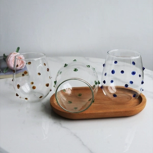 Irregular textured glass cups with colored dots on a luxury wooden tray for juice or milk
