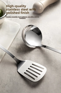 Close-up of polished stainless steel soup ladle and slotted turner with mirror finish
