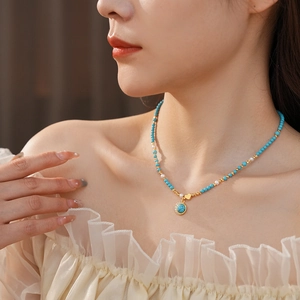 Gros plan du collier cœur plaqué or avec perles turquoise et perle sur mannequin